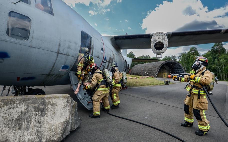 Firefighters assigned to the 86th Civil Engineer Group rescue a victim mannequin trainer during a simulated aircraft crash scenario at Ramstein Air Base, Germany, July 26, 2022.