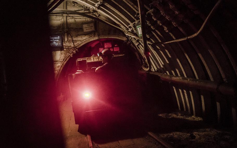 Coal miners travel by rail through miles of underground tunnels during their shift. 