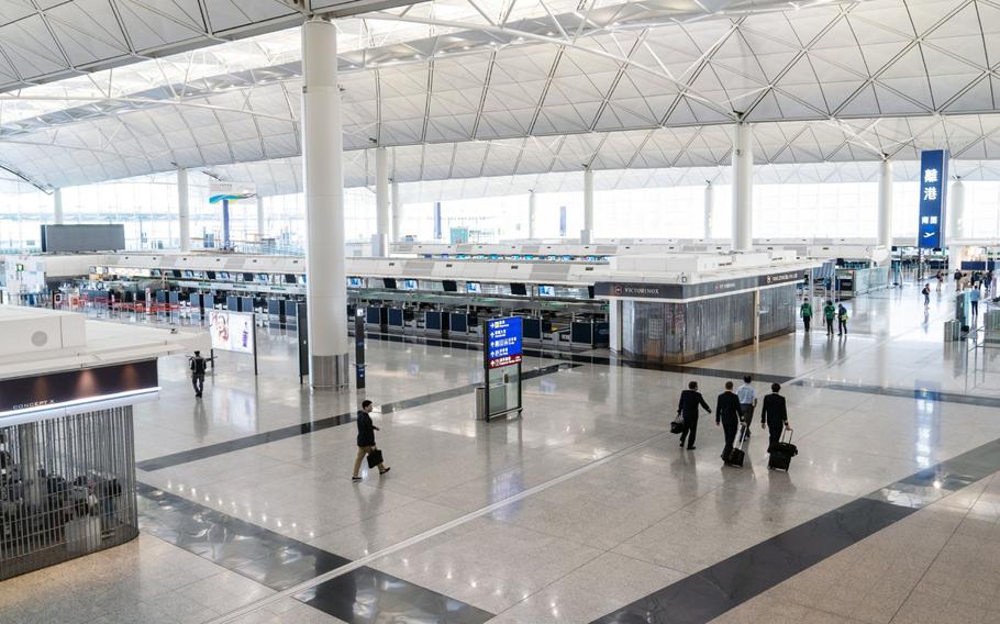 Airline crew members walk through the departure hall at Hong Kong International Airport in Hong Kong on Nov. 29, 2021. 