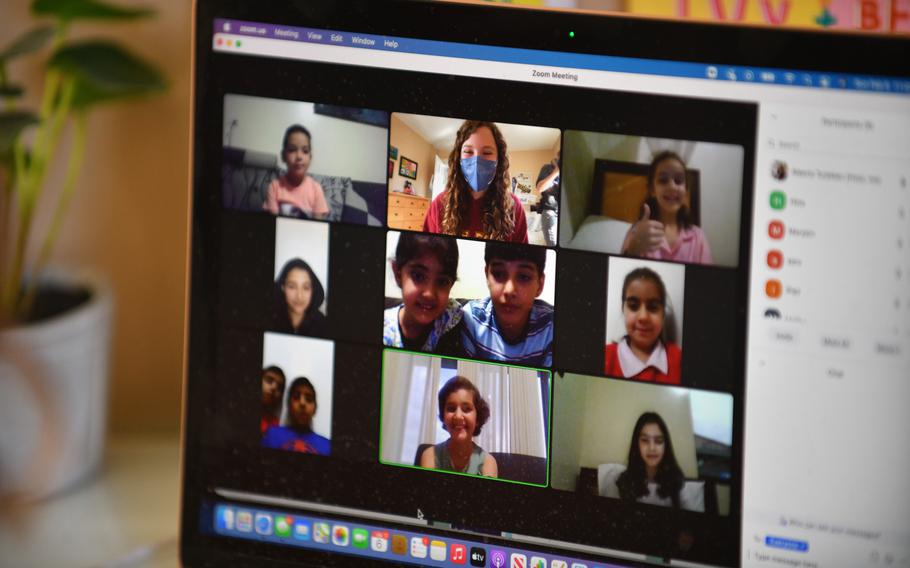 Young Afghan refugees are seen on the laptop computer during a zoom session with Aleena Turekian, 12, (top row, center) of her book club at her family home in Washington, D.C., February 6, 2022. With her book club zoom sessions Aleena tries to help Afghan evacuees who live in Rwanda, U.S. military bases and Virginia, to learn English and a few American colloquialisms. Some of the literature she uses is the Ivy and Bean series about the adventures of two 8-year-old girls in suburban America.