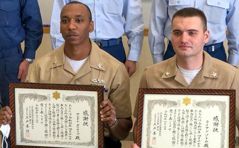 Petty Officer 1st Class Andre Griffith, 29, left, and Petty Officer 2nd Class Ryan Sorrem, 26, received letters of appreciation from the Hachinohe, Japan, Fire Department for rescuing a motorist trapped in a car filliing with smoke in April.