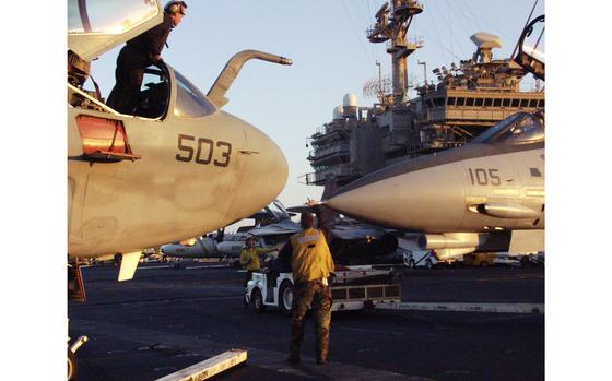 Persian Gulf, March, 2003: A sailor in an EA-6B Prowler, left, looks down at a fighter jet that gets close to the aircraft while it's being parked on the USS Kitty Hawk flight deck.

META TAGS: Iraq; U.S. Navy, Operation Iraqi Freedom; combat; Wars on Terror;USS Kitty Hawk; aircraft carrier; supercarrier