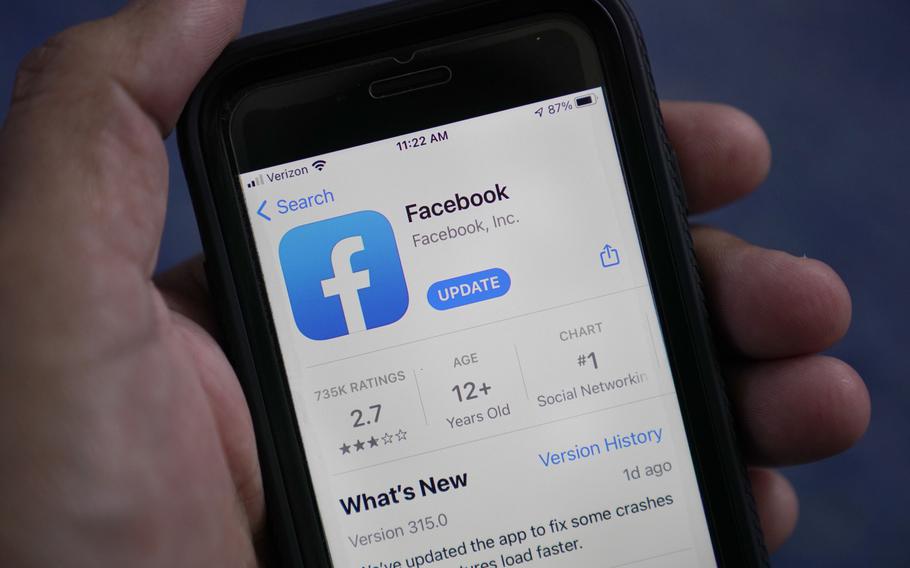 The Facebook app is shown on a smart phone on April 23, 2021, in Surfside, Fla.  Facebook announced on Thursday, May 27,  that it will no longer remove from its apps claims that COVID-19 is man-made or manufactured.