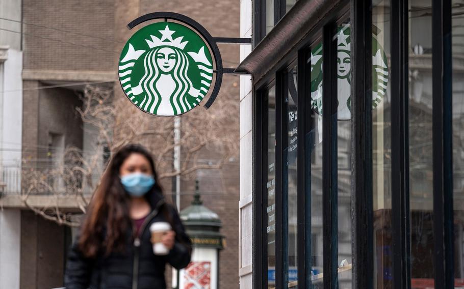 A person walks past a Starbucks coffee shop in San Francisco on Jan. 21, 2021. Starbucks said its U.S. employees must be vaccinated against COVID-19 or submit to weekly testing by Feb. 9, 2022.