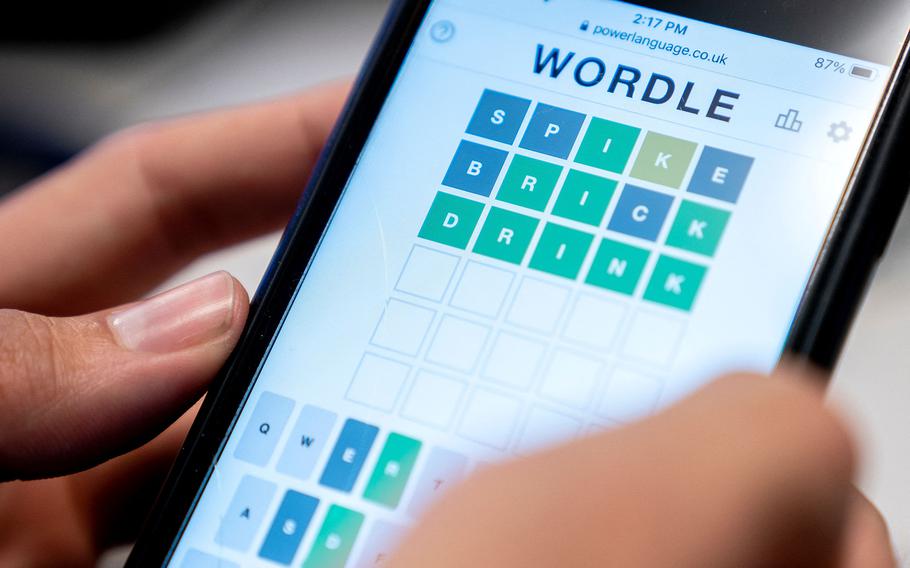 This photo illustration shows a person playing online word game “Wordle” on a mobile phone.