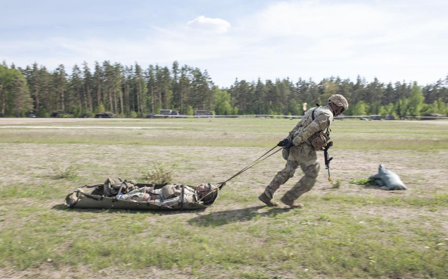 A soldier runs while dragging a casualty dummy.