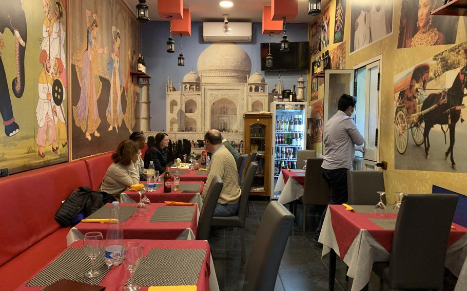 The cozy indoor dining room at Taj Mahal in Naples, Italy features a giant-sized photo of the Taj Mahal in India on its back wall.