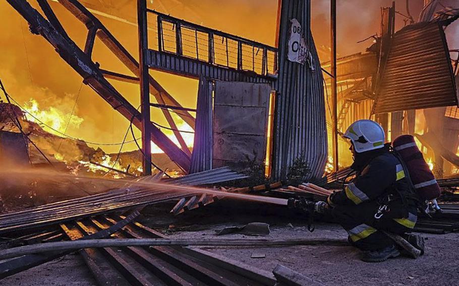 Emergency services personnel work to extinguish a fire following a Russian attack in Lviv, Ukraine, Tuesday, Sept. 19, 2023.