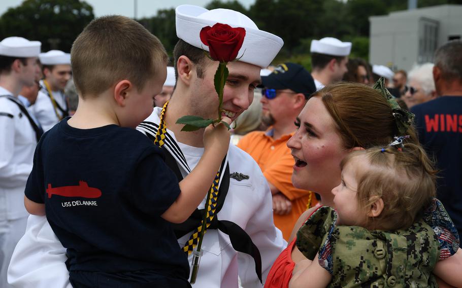 A sailor embraces his family