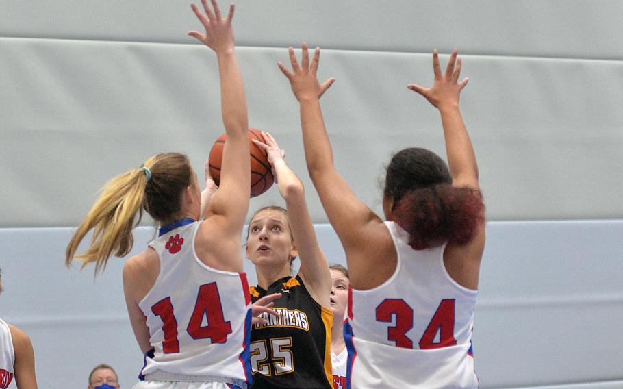 Stuttgart’s Erin Whitten eyes the basket as she shoots over Ramstein’s Spice Harris, left, and Alysha Edwards in opening day play at the DODEA-Europe Division I championships in Ramstein, Germany, Feb. 23, 2022. Stuttgart won 32-30.