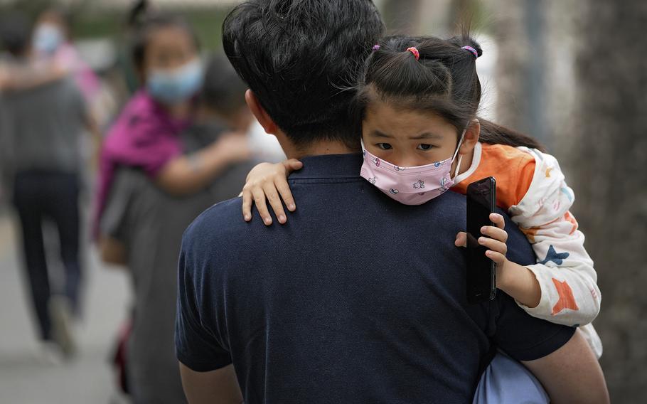 A child is carried to a kindergarten in Beijing on June 9, 2021. If China is to meet its tentative goal of vaccinating 80% of its population against the coronavirus by the end of the year, tens of millions of children may have to start rolling up their sleeves.