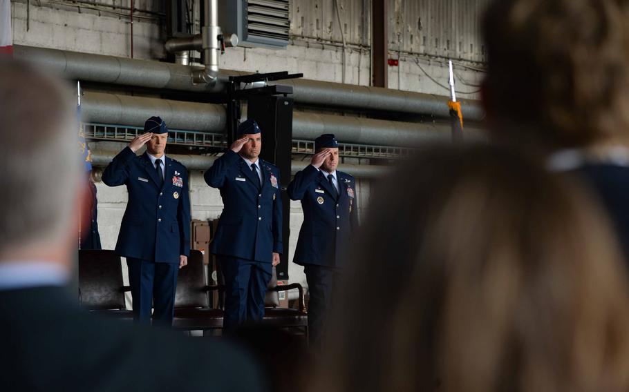From left, Maj. Gen. Derek France, the Third Air Force commander; Col. Leslie Hauck, the outgoing commander of the 52nd Fighter Wing; and Col. Kevin Crofton, the incoming commander, salute during the playing of the national anthem June 2, 2023, at Spangdahlem Air Base, Germany. France marked the formal transfer of leadership responsibilities from Hauck to Crofton.