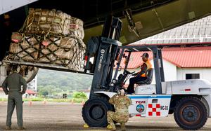 A forklift operator transports a palletized load from the C-5’s rear cargo ramp while ground crews signal in Panama City, Panama, Aug. 30, 2025. The shipment, more than 167,000 pounds packed in four 40-foot containers totaling over 5,000 boxes, was consigned to Fundación Castillo Del Rey, a Panamanian non-governmental organization, for nationwide distribution. (U.S. Air Force photo by Capt. Jymil Licorish)