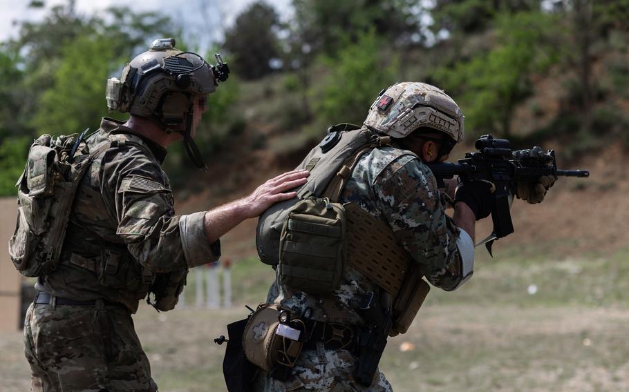 A U.S. soldier assigned to 10th Special Forces Group leads his counterpart from North Macedonia through a stress shooting drill in May 2021 as part of Exercise Trojan Footprint 21. This year's Trojan Footprint, a drill that involves missions across southeastern Europe, the Baltics and Black Sea Region, got underway May 2. 