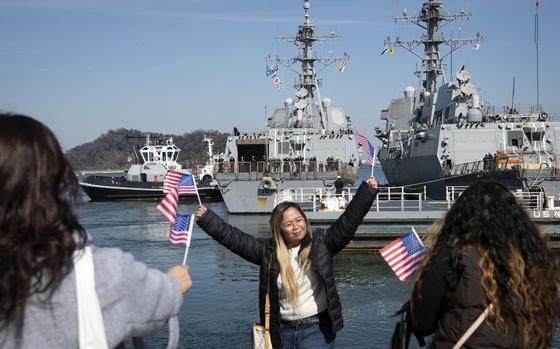 Family members of sailors assigned to the USS John Finn cheer as the guided-missile destroyer arrives at Yokosuka Naval Base, Japan, Saturday, March 4, 2023.