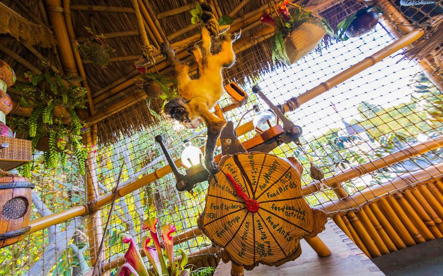 Humorous scenes, such as this monkey trying to manipulate a feeder, dot the newly-imagined Adventureland Treehouse at Disneyland Park in Anaheim, Calif. 