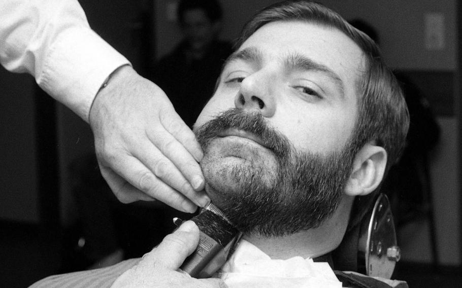 Petty Officer 1st Class Colin Rogers has his beard shaved off at the barber shop at Patch Barracks in Stuttgart, Germany, on Dec. 30, 1984, the day before the service's deadline for beard removal.