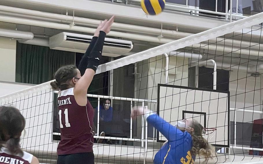 Yokota’s Devynn Martin bumps the ball at the net as Seisen‘s Ariana Hill looks to block during Wednesday’s Kanto Plain volleyball match. The Phoenix won in straight sets.