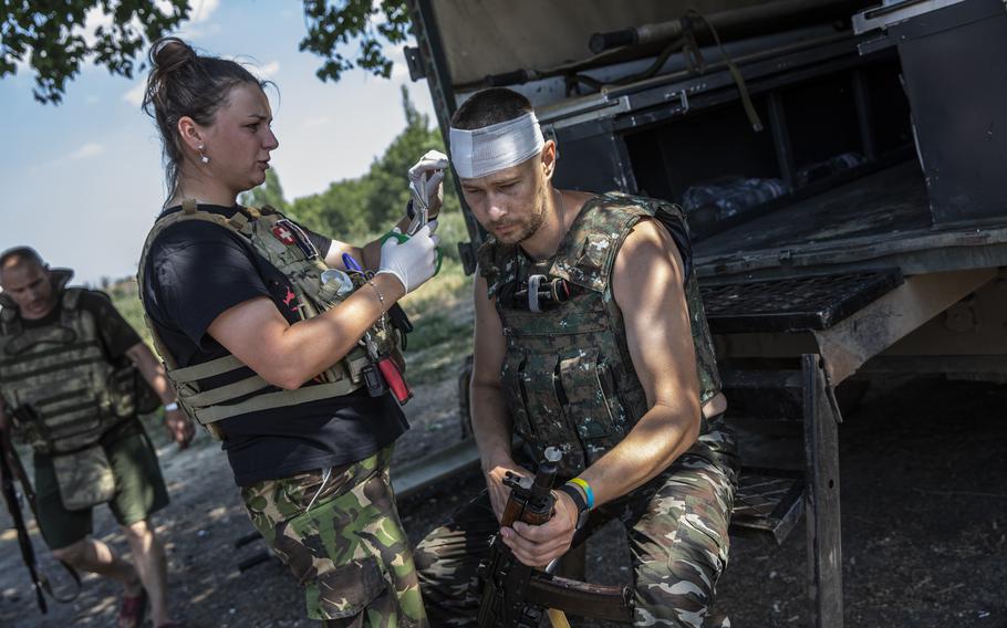 Hanna Khurava, a medic in the Ukrainian military as she treats Dema, 37, a soldier lightly wounded after Russian forces retaliated following Ukrainian forces firing a Grad missile battery in Perelzne, Ukraine, on July 1, 2022. 