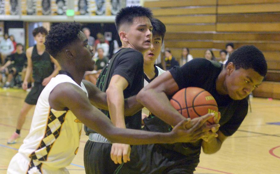 Kubasaki's Jordan Sellers pulls away with a rebound from Kadena's Cedrick Dorelien during Friday's DODEA-Okinawa boys basketball game. The Panthers won 58-29, improving to 3-0 against the Dragons this season.