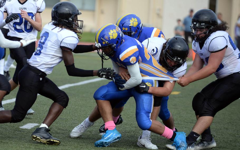 Yokota's Casey Bumpers gets bottled up by several Osan defenders.