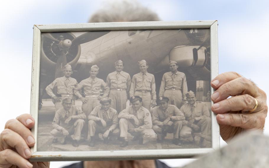 A woman holds a vintage photo in front of her face.