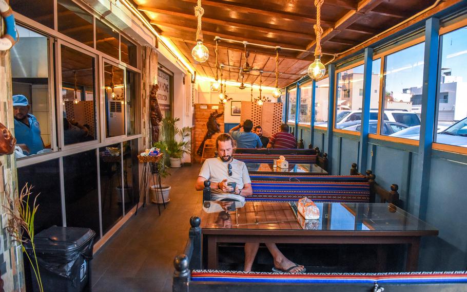 A diner sits at a table at a restaurant that serves fresh fish.