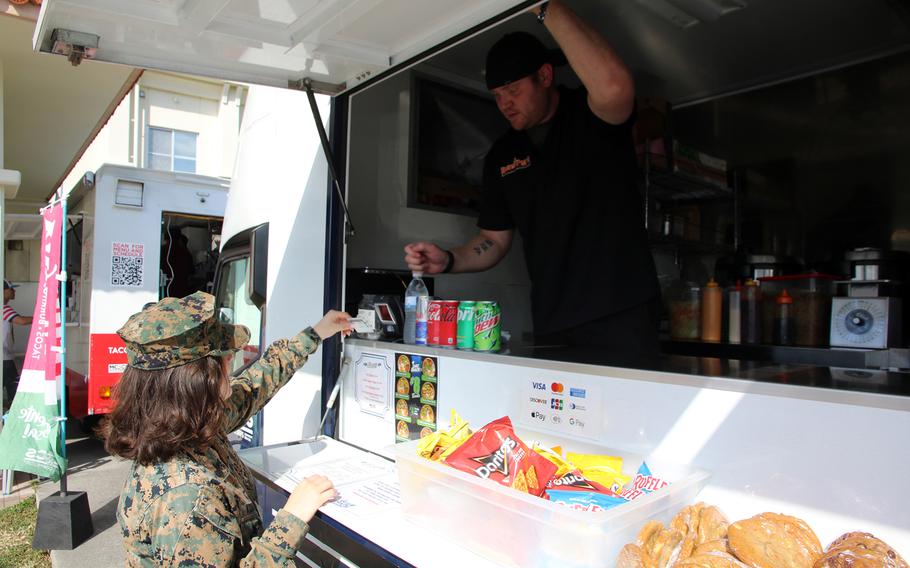 Cpl. Jordan Kuzniak, an air support operator with Marine Air Support Squadron 2, orders lunch through the Mobile Feeding Pilot Program at the Camp Foster, Okinawa, Nov. 29, 2023.