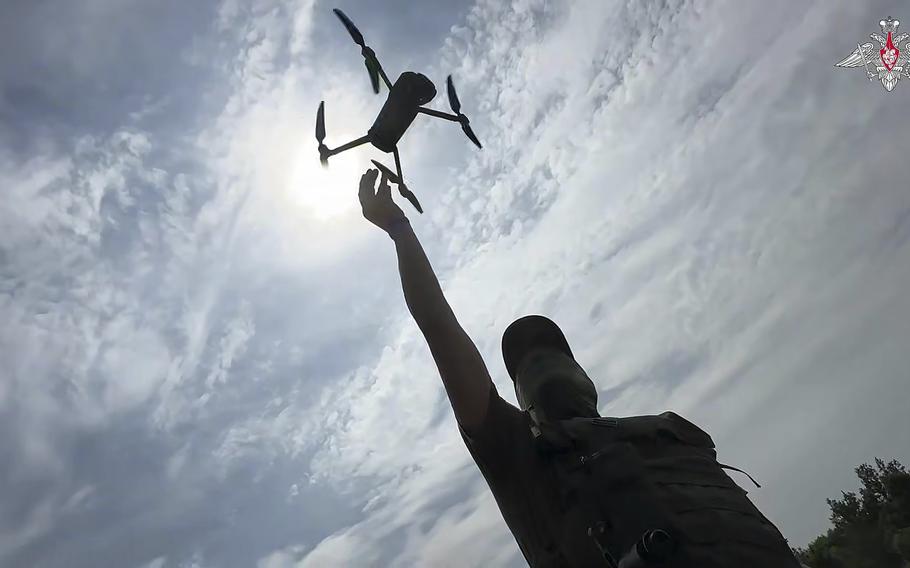 A Russian soldier throws a Russian drone in the air.