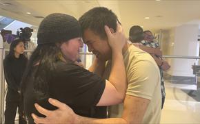 Andy Huynh, left, and Alex Drueke, far right, are seen hugging their loved ones after arriving at Birmingham-Shuttlesworth International Airport in Birmingham, Ala., Saturday, Sept. 24, 2022. The U.S. military veterans disappeared three months ago while fighting Russia with Ukrainian forces. They were released earlier this week by Russian-backed separatists as part of a prisoner exchange. 