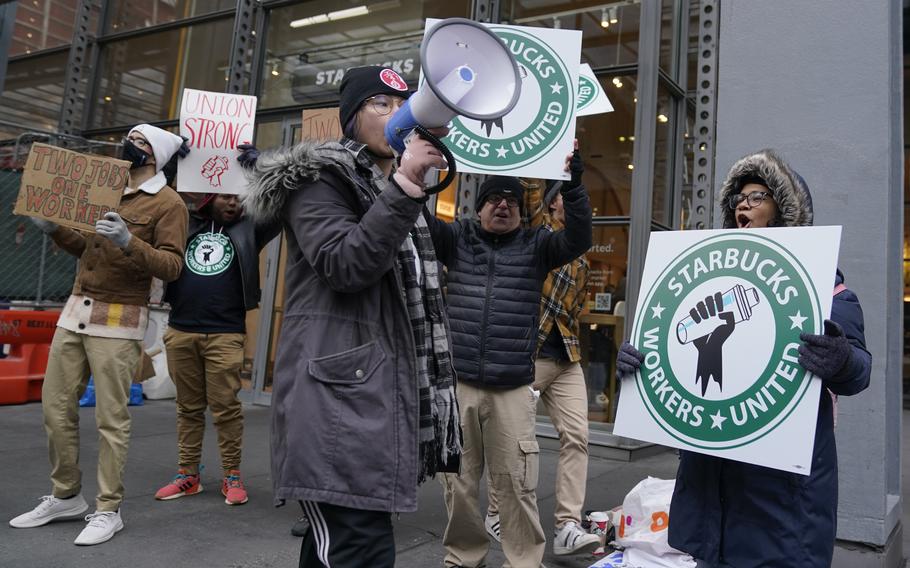 People chant and hold signs in front of a Starbucks in New York, Thursday, Nov. 17, 2022. Starbucks workers at more than 100 U.S. stores say they’re going on strike Thursday in what would be the largest labor action since a campaign to unionize the company’s stores began late last year. 