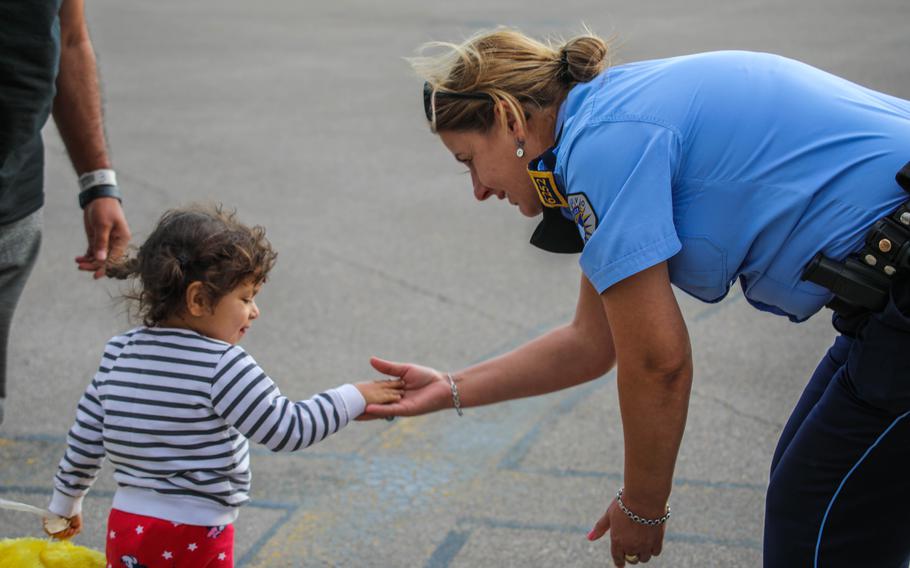 A member of the Kosovo Police greets Afghan evacuees at the Pristina International Airport, Pristina, Kosovo, Sept., 20, 2021