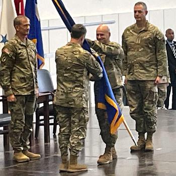 A guidon is passed during a change of command.