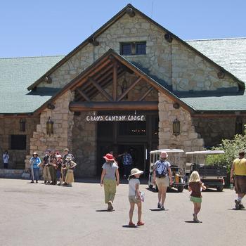 Tourists walk in front of the entrance to the lodge.