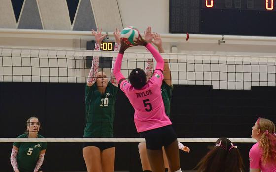 Vicenza's Ally Taylor softly hits the ball over a pair of Wildcat defenders during the first set as the Vicenza Cougars play the Naples Wildcats at Vicenza High School on Oct. 13, 2023. The Wildcats would go on to win the first set 25-20.
