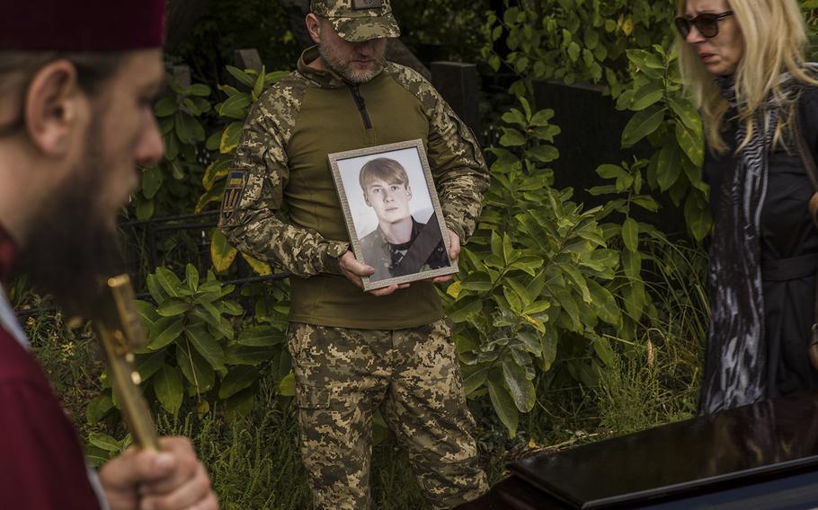 Family and friends of Oleh Finogenov, who was killed by shelling near Izyum, gather at St. Volodymyr Cathedral in Kyiv for a memorial ceremony. 