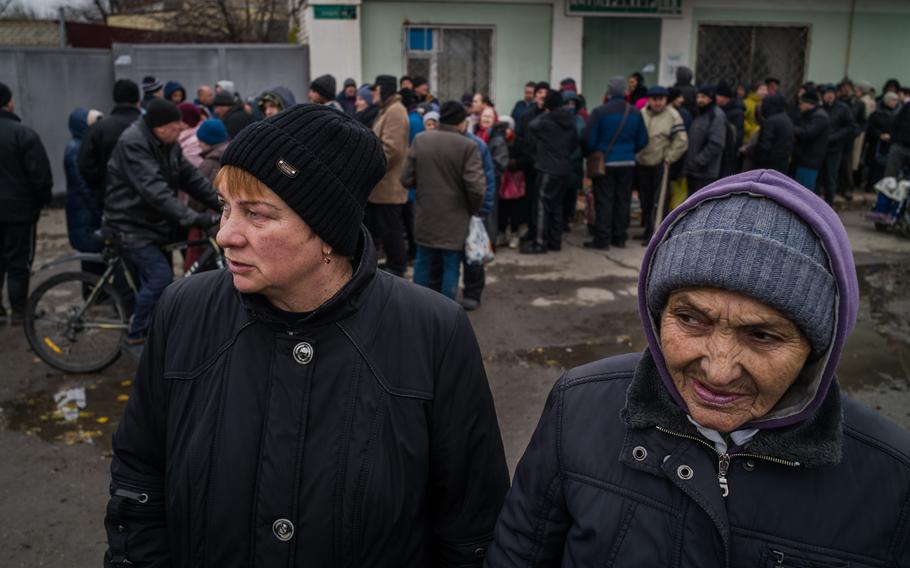 People waiting for the humanitarian aid in Antonivka on Tuesday.
