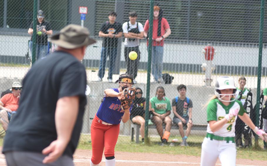 SHAPE assistant coach Mike Hurd shouts encouragement as Colie Meyer races to first to try to beat the throw of Ramstein pitcher Kelsey Moya on Wednesday, May 21, 2025, on the opening day of the DODEA-Europe Division I softball championships at Kaiserslautern, Germany.