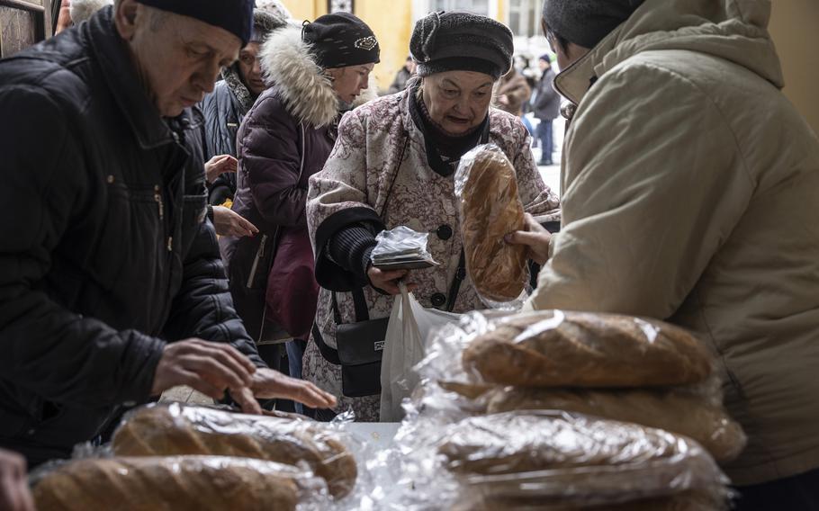 Volunteers distribute loaves of bread to civilians in the eastern Ukrainian city of Kramatorsk on Feb. 15, 2023.