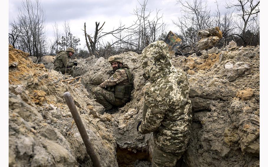 Ukrainian infantrymen take cover in a  trench outside of Bakhmut, Ukraine, on March 5, 2023. 
