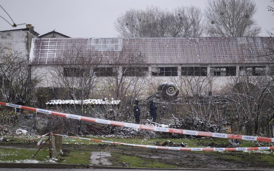 Police look for pieces of a missile at an explosion site in Przewodow, Poland, on Nov. 17, 2022.