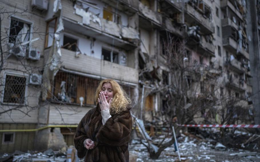 Natali Sevriukova reacts next to her house following a rocket attack the city of Kyiv, Ukraine, on Feb. 25, 2022.