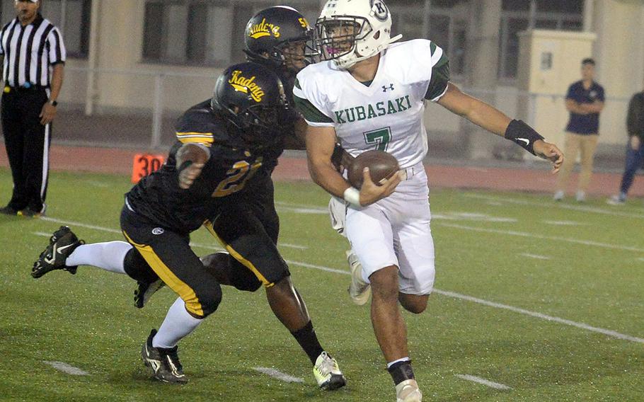 Kubasaki quarterback A.J. Millette is hemmed in by Kadena's D'Kylan Woods and Jason Jackson.