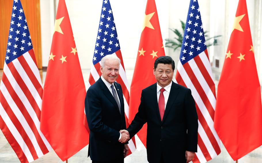 Chinese President Xi Jinping, right, shakes hands with then U.S Vice President Joe Biden inside the Great Hall of the People on Dec. 4, 2013, in Beijing.