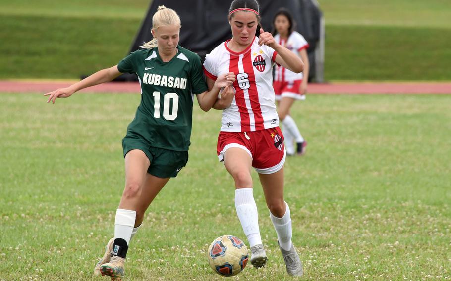 Kubasaki's Hailey Stoudemayer and Nile C. Kinnick's Julia Angelinas chase the ball during the Dragons' 2-0 win over the Red Devils in Tuesday's Division I girls soccer semifinal.