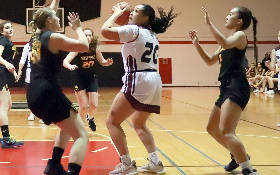 Zama's Deborah McClendon looks to shoot between American School In Japan defenders during Tuesday's Kanto Plain girls basketball game. The Trojans rallied late to win 34-32.