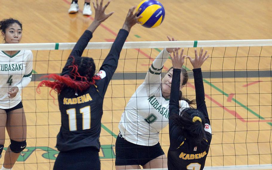 Kubasaki's Ava Serna spikes between Kadena's Liza Young and Bre Castillo during Tuesday's Okinawa girls volleyball match. The Dragons won in four sets.