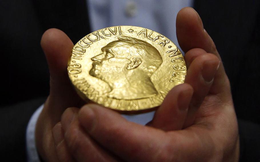 Bidder Ole Bjorn Fausa, of Norway, holds the 1936 Nobel Peace Prize medal in Baltimore, March 27, 2014, the second Nobel Peace Prize ever to come to auction. The Nobel Peace Prize that Russian journalist Dmitry Muratov was auctioning off to raise money for Ukrainian child refugees has sold for $103.5 million.