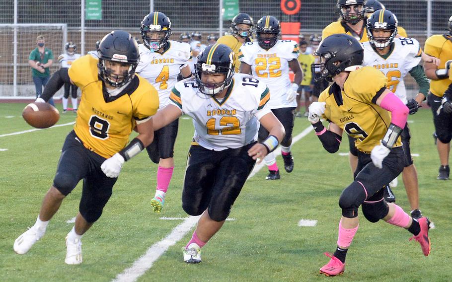 American School In Japan running back Stefan Merino tries to outrun Robert D. Edgren defender Jayse Ulechong while getting a hand from teammate Gregor Rolls.