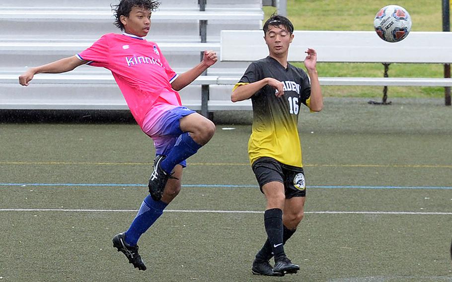 Nile C. Kinnick's Cameron Giddens boots the ball past Kadena's Skylar Dluzeski.